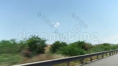 在塞浦路斯拉纳卡，POV从车窗<strong>驶过</strong>田野、树木和风车